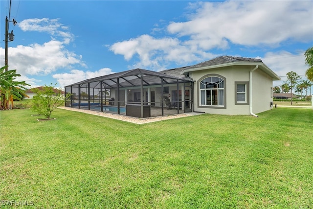 rear view of house with glass enclosure and a yard