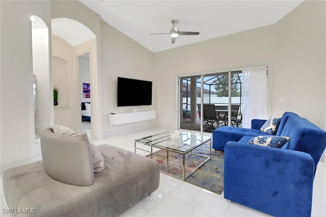 living room with ceiling fan, light tile patterned floors, and vaulted ceiling