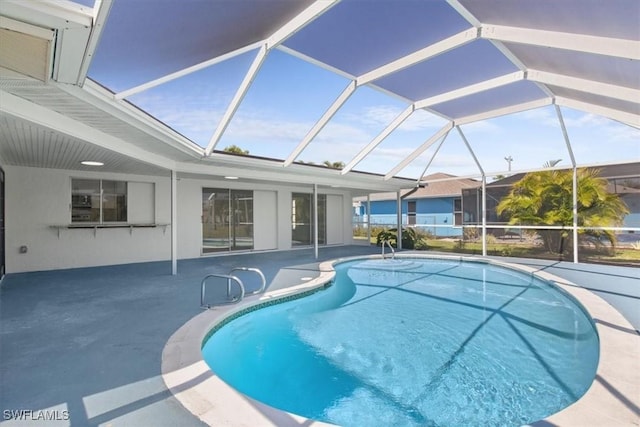 view of swimming pool with glass enclosure and a patio area