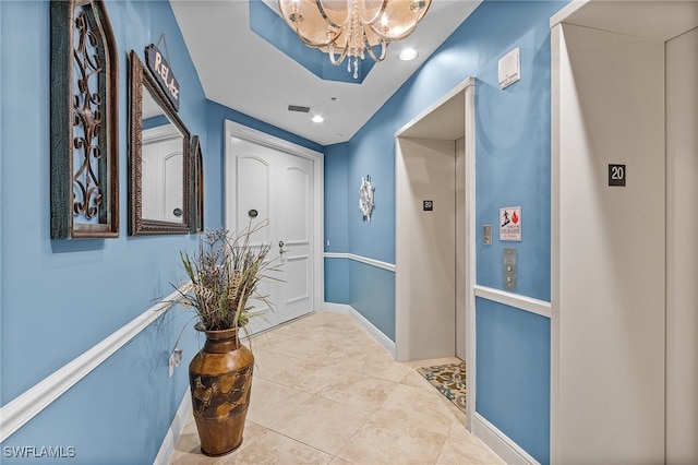 corridor with a notable chandelier and light tile patterned flooring