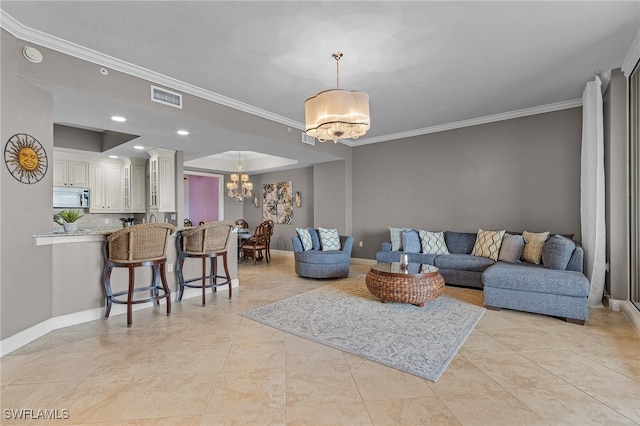 living room with crown molding and a chandelier