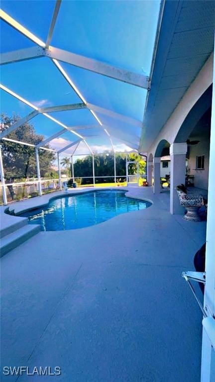 view of pool with a patio and glass enclosure