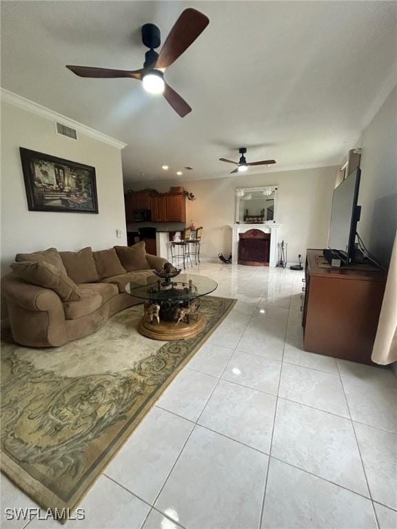 living room with crown molding, light tile patterned flooring, and ceiling fan