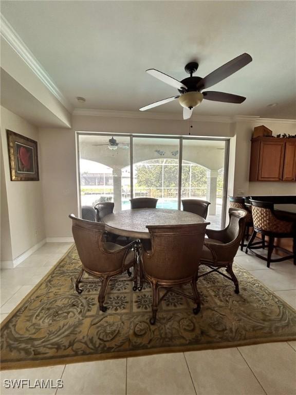 tiled dining room with crown molding and ceiling fan