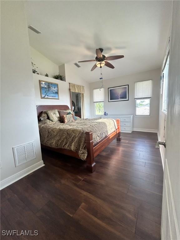 bedroom with dark wood-type flooring, ceiling fan, and vaulted ceiling