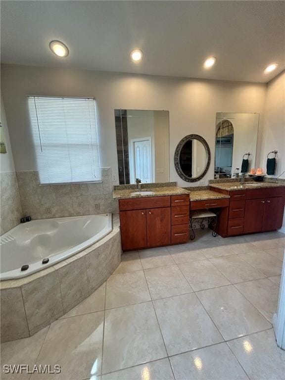 bathroom with vanity, tile patterned flooring, and a relaxing tiled tub