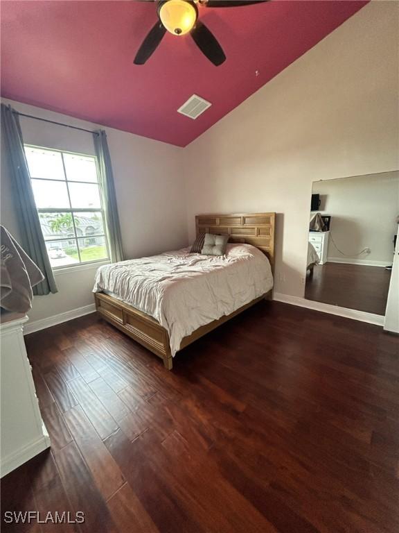 bedroom with lofted ceiling, dark hardwood / wood-style floors, and ceiling fan