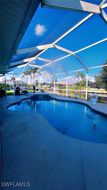 view of swimming pool featuring a lanai and a patio area