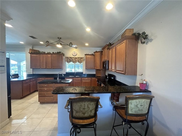 kitchen with light tile patterned flooring, crown molding, a kitchen breakfast bar, kitchen peninsula, and black range with electric stovetop