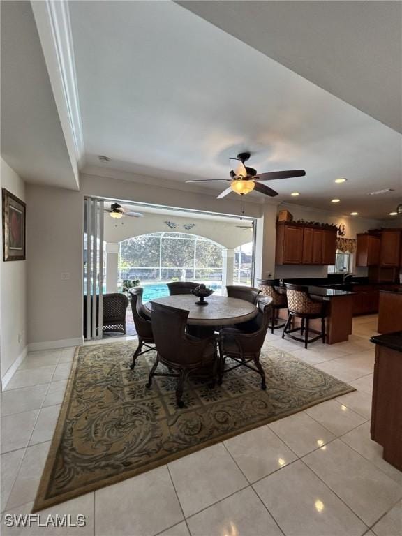 dining space with light tile patterned flooring and ornamental molding