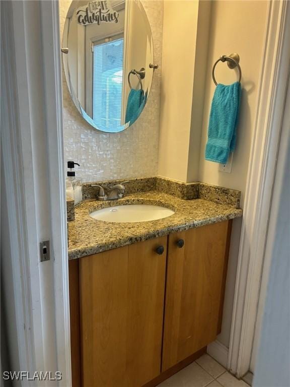 bathroom with tasteful backsplash, vanity, and tile patterned flooring