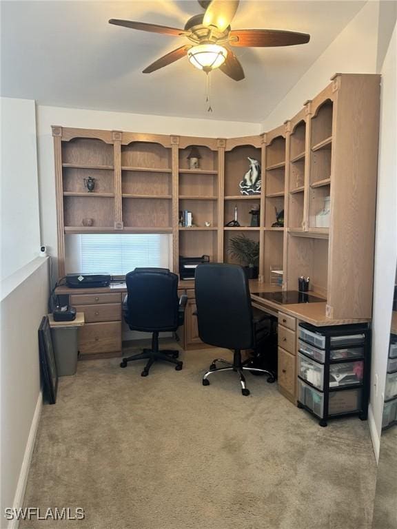 home office with baseboards, a ceiling fan, and light colored carpet