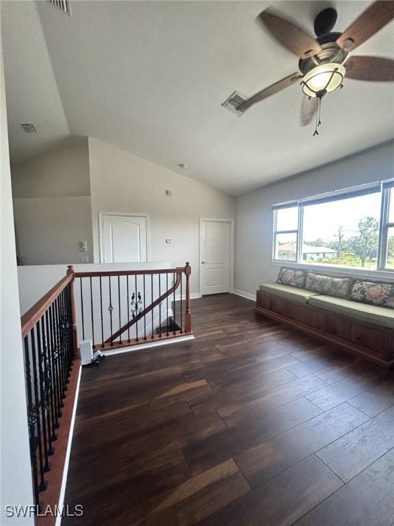 interior space with visible vents, vaulted ceiling, baseboards, and wood finished floors