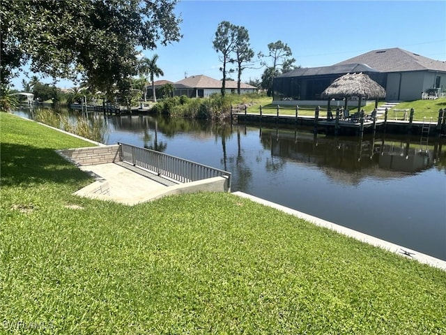 dock area with a water view and a lawn