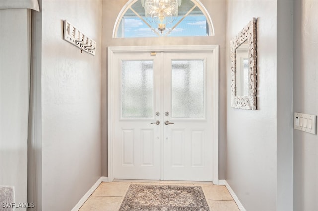 doorway featuring french doors, light tile patterned floors, and a chandelier