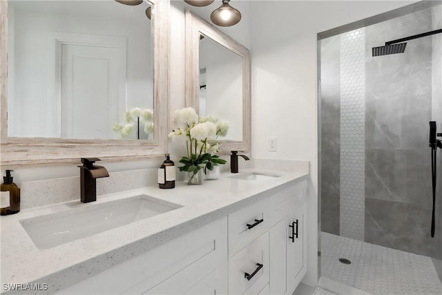 bathroom featuring tiled shower and vanity