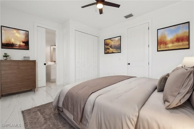 bedroom featuring ceiling fan, ensuite bathroom, and two closets