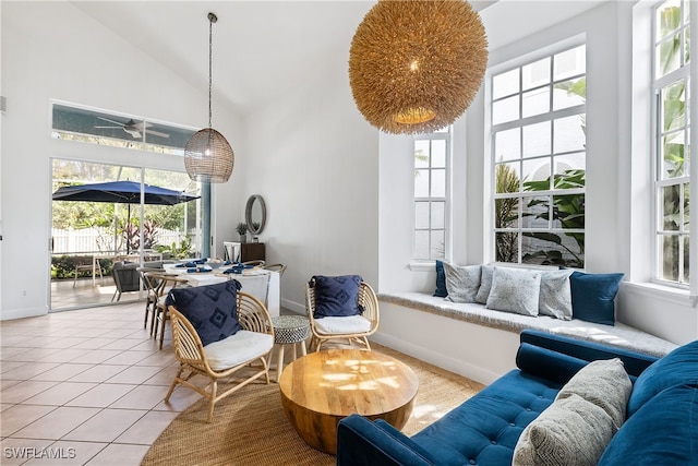 living room featuring light tile patterned floors, high vaulted ceiling, and a wealth of natural light