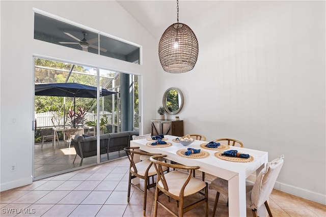 tiled dining space with high vaulted ceiling and ceiling fan