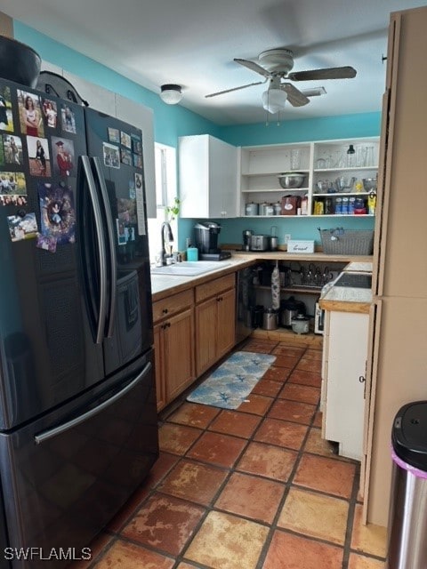 kitchen with ceiling fan, sink, tile countertops, and black fridge