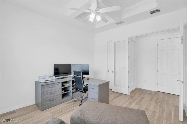 office space featuring ornamental molding, coffered ceiling, light hardwood / wood-style flooring, and ceiling fan