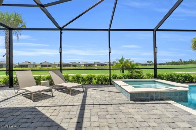 view of swimming pool featuring a patio area, an in ground hot tub, and a lanai