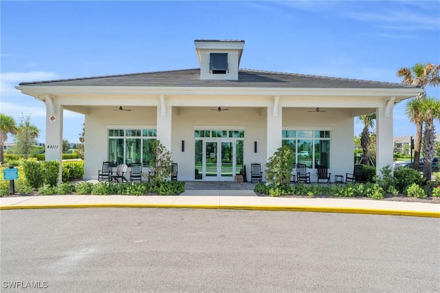 exterior space featuring a ceiling fan, french doors, and stucco siding