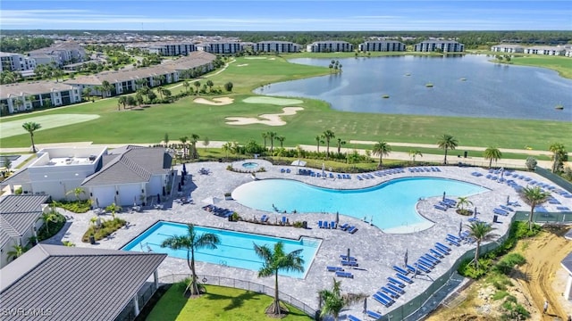 drone / aerial view with golf course view and a water view