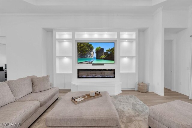 living room with light wood-type flooring and crown molding