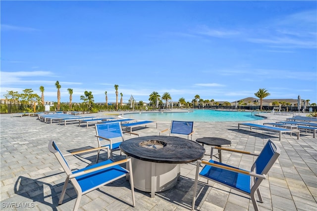 view of swimming pool with an outdoor fire pit and a patio