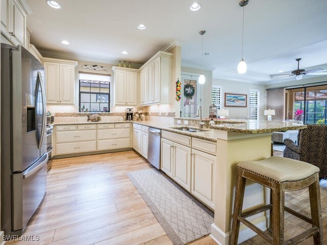 kitchen featuring kitchen peninsula, sink, hanging light fixtures, and appliances with stainless steel finishes