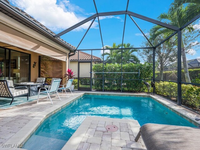 view of swimming pool with a patio and glass enclosure