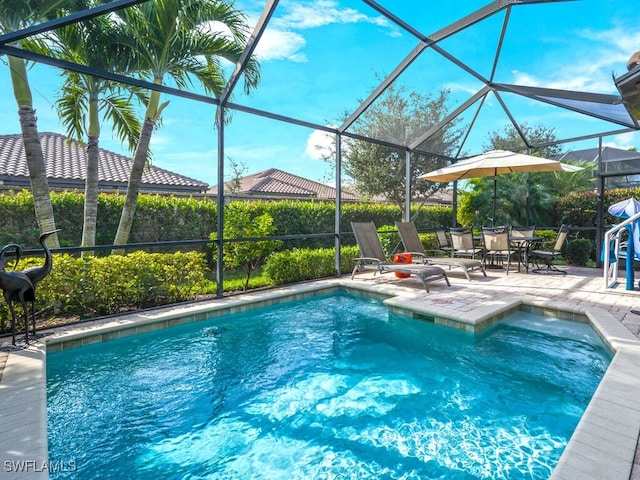 view of swimming pool with a patio area and glass enclosure