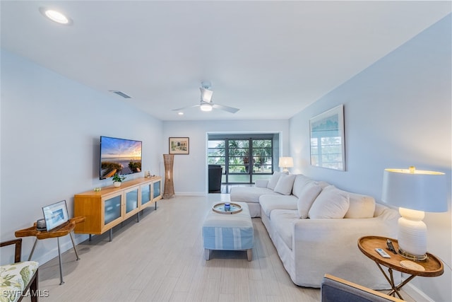 living room featuring ceiling fan and light hardwood / wood-style flooring