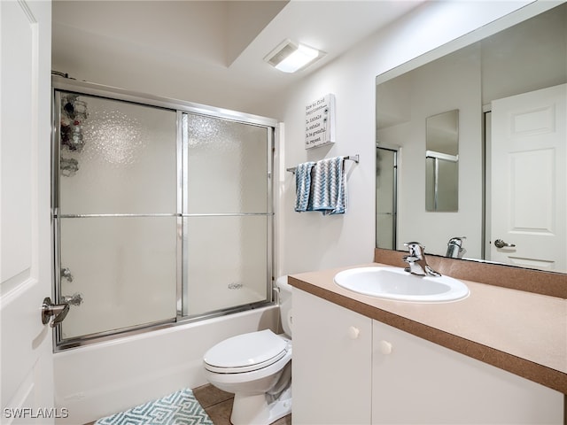 full bathroom featuring tile patterned floors, shower / bath combination with glass door, toilet, and vanity