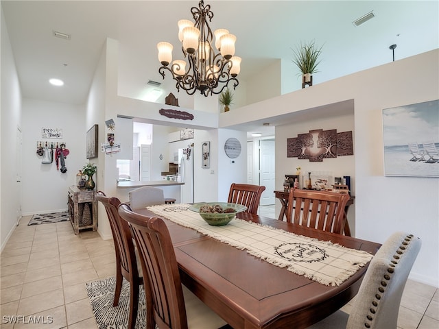 dining room featuring light tile patterned floors, an inviting chandelier, and a high ceiling