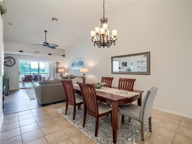 dining area with lofted ceiling, ceiling fan with notable chandelier, and light tile patterned flooring