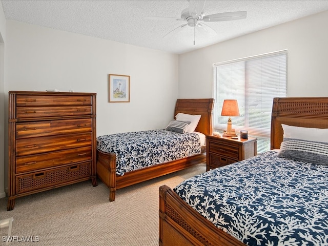 carpeted bedroom with ceiling fan and a textured ceiling