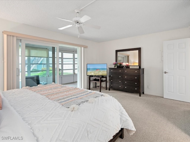 carpeted bedroom featuring ceiling fan, access to exterior, and a textured ceiling