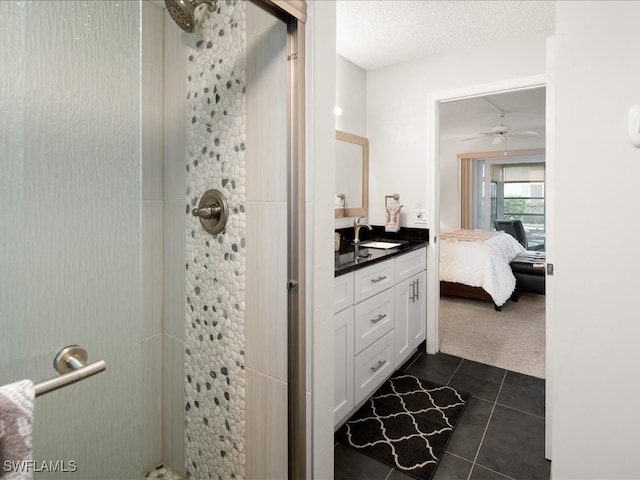 bathroom featuring a shower, ceiling fan, vanity, and tile patterned floors