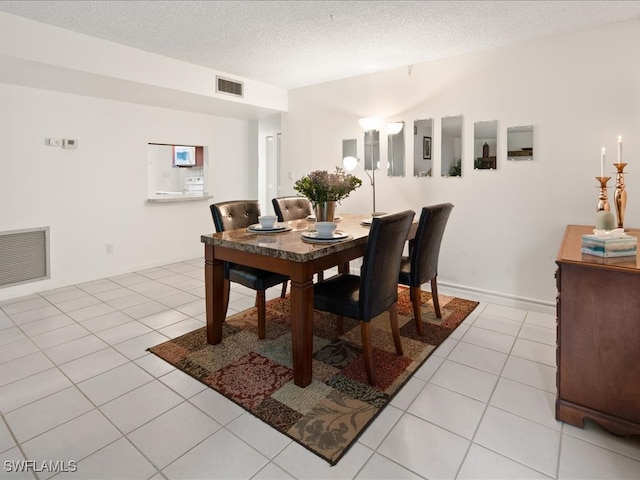 tiled dining area featuring a textured ceiling