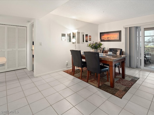 tiled dining area with a textured ceiling