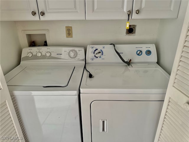 clothes washing area featuring cabinets and washing machine and clothes dryer