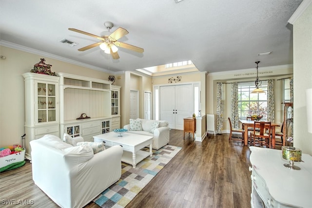 living room with ceiling fan, hardwood / wood-style flooring, crown molding, and a textured ceiling