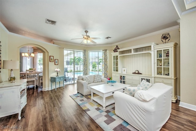 living room featuring ceiling fan with notable chandelier, a wealth of natural light, dark hardwood / wood-style floors, and crown molding