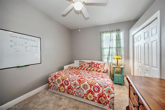 bedroom with light colored carpet, ceiling fan, and a closet