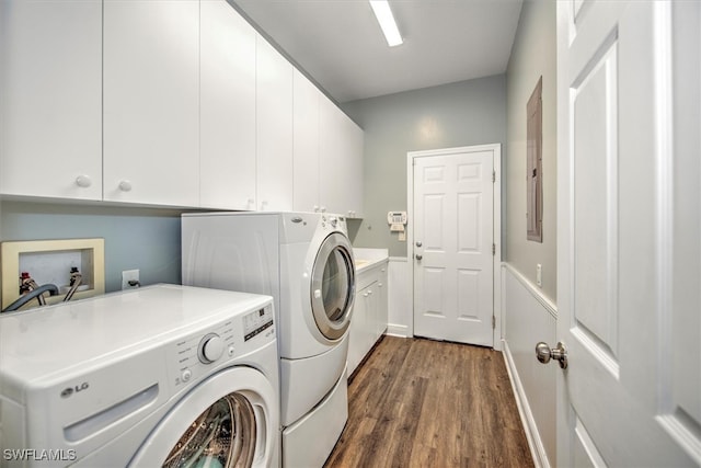 laundry room featuring cabinets, washer and clothes dryer, and dark wood-type flooring