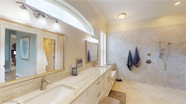 bathroom with ornamental molding, tiled shower, vanity, and tile patterned floors