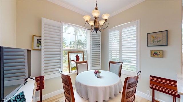 dining area with ornamental molding, light hardwood / wood-style flooring, and a chandelier