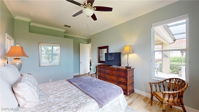 bedroom with multiple windows, light hardwood / wood-style floors, ornamental molding, and ceiling fan